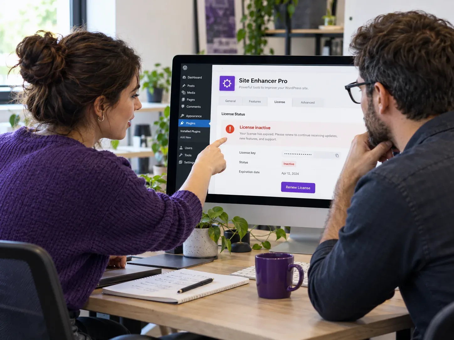 Dos profesionales revisan en un monitor la licencia inactiva de un plugin de WordPress
